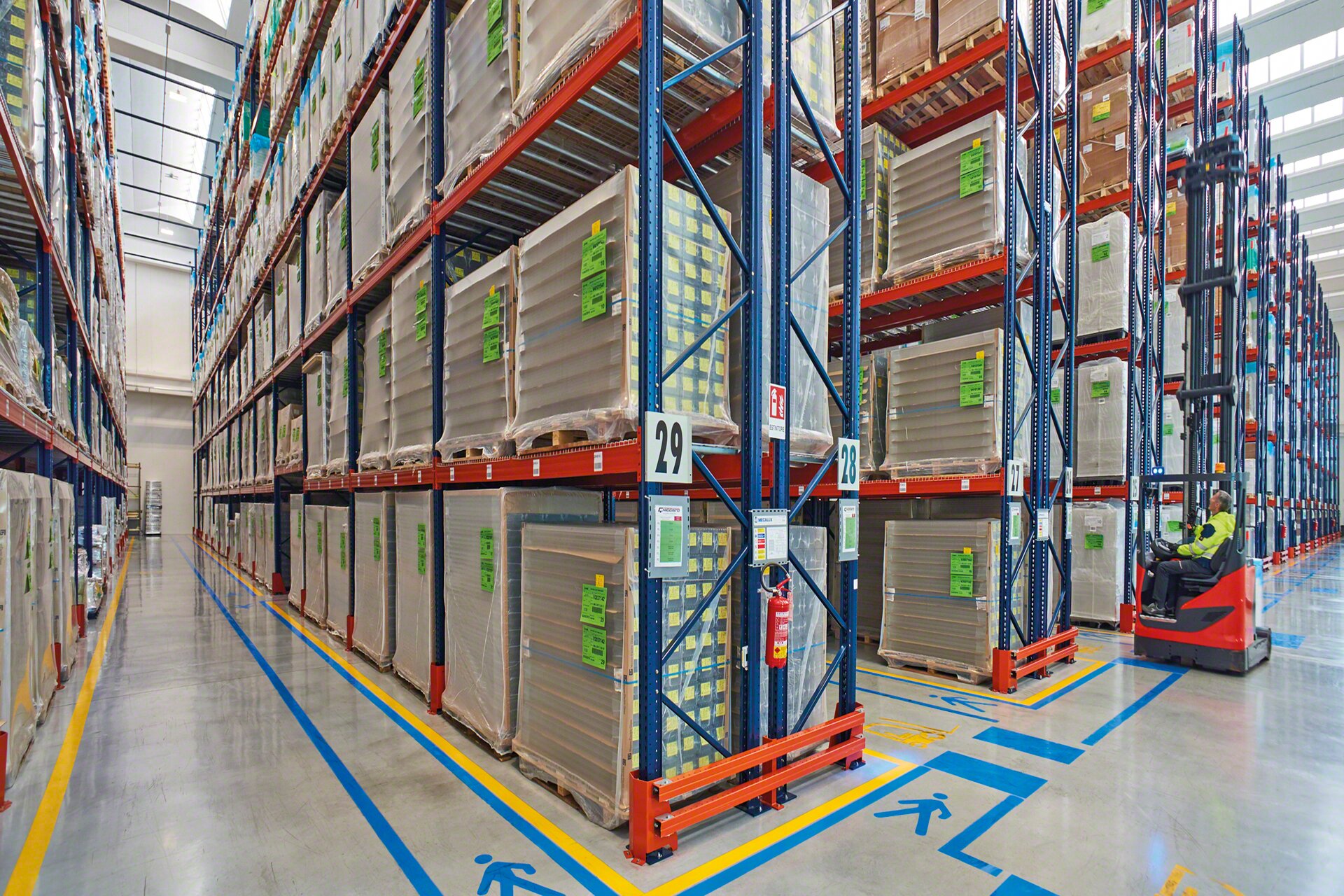 A sinalização viária nos corredores de trabalho reforça a segurança da instalação em um armazém de paletes